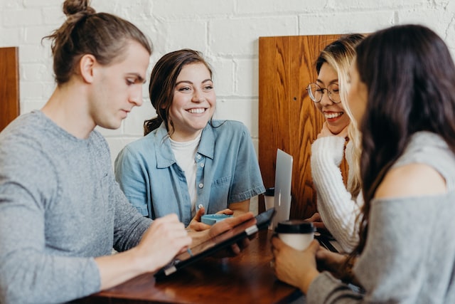 Four property managers from a property management company sitting at a table smiling and talking